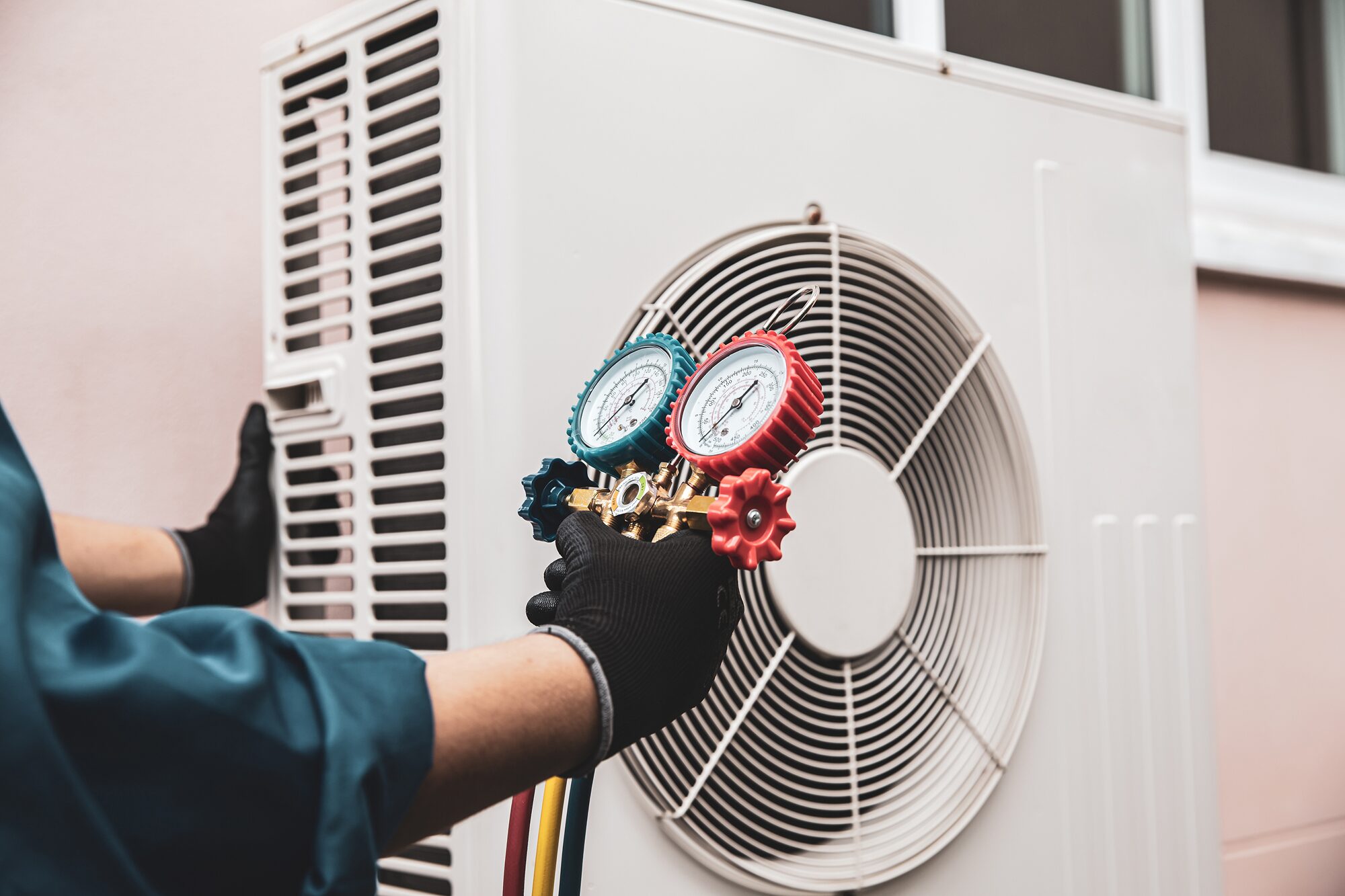HVAC technician checking refrigerant pressure on an outdoor heat pump unit in Vancouver, WA