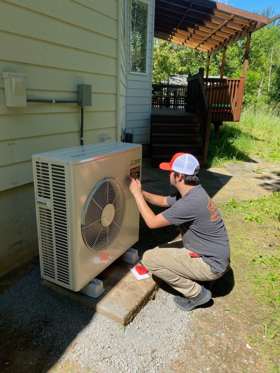 Tri-Tech Heating, Inc. technician servicing a ductless heat pump outdoor unit at a Vancouver WA home
