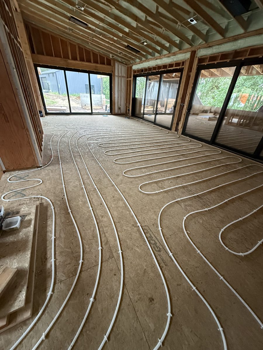 Radiant floor heating loops fastened across the subfloor of a new home's great room